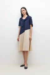 Vestido a la rodilla azul marino y beige, con corte evasé y mangas cortas.