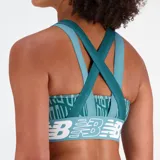 Top deportivo New Balance color verde azulado con estampado de letras y logo de la marca en blanco.