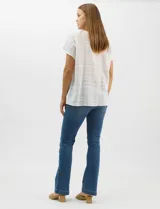 Blusa de corte fluido confeccionada en algodón con tejido texturizado de patrón a cuadros. Presenta mangas cortas caídas, escote redondo y cierre frontal con botones.