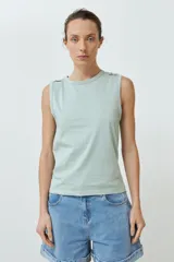 Musculosa de algodón color rojo, con cuello redondo, corte sin mangas y detalle de botones decorativos en los hombros.