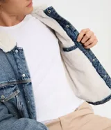 Campera de jean de corte regular, con cuello de solapa forrado en chenille, cierre frontal con botones metálicos y bolsillos frontales en el pecho.