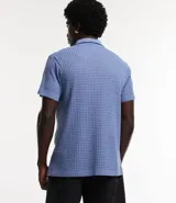 Camisa celeste de punto calado con cuello inglés, manga corta y abotonadura frontal.