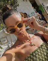 Collar con dije de bronce macizo con forma orgánica irregular, similar a un coral, suspendido de un cordón negro de seda natural anudado.