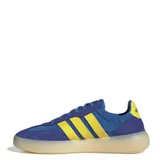 Championes Adidas Barreda Decode de estilo retro, con diseño inspirado en el calzado de fútbol. Presentan una combinación de colores azul y amarillo, con la clásica puntera en forma de T y las tres bandas laterales características de la marca. Cuentan con una mediasuela de aspecto translúcido y suela de goma.