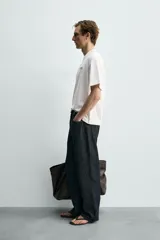 Camiseta de corte relajado, cuello redondo y manga corta. Presenta un pequeño estampado de texto en el pecho y un estampado gráfico de mayor tamaño en la espalda.