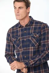 Sobrecamisa de estilo leñador con estampado de cuadros, confeccionada en tela de viyela. Presenta cuello clásico, cierre frontal con botones y dos bolsillos con solapa en el pecho.