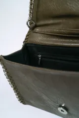 Cartera de hombro con solapa y bordes ribeteados con una cadena metálica entrelazada. Presenta un diseño tipo sobre con acabado texturizado y una correa de cadena larga.