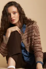 Cardigan corto de tejido jacquard con diseño geométrico en tonos marrón y beige. Presenta cuello en V, cierre frontal con botones y puños acanalados.