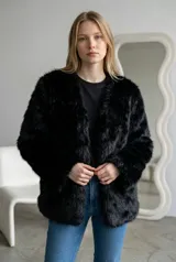 Abrigo de piel sintética en color negro, con diseño de corte recto, manga larga y frente abierto sin cierres ni botones.