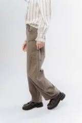 Jean de corte wide leg y tiro alto, confeccionado en denim de color azul oscuro. Presenta costuras decorativas visibles en los laterales y un diseño de pierna amplia.