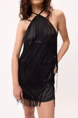 Vestido corto negro de satén con escote halter y espalda descubierta. Presenta múltiples flecos largos en el frente y ruedo.