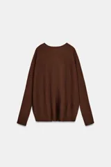 Jersey de punto con cuello redondo y manga larga, diseñado con un cuerpo amplio estilo capa y sisa ancha.