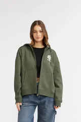 Campera de felpa verde militar con capucha, cierre frontal completo y bolsillos estilo canguro. Presenta un pequeño estampado floral blanco en el pecho con el logo de la marca.