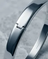 Esclava rígida de acero inoxidable con acabado pulido brillante y diseño minimalista.