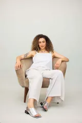 Sandalias de cuero color marrón con puntera abierta, talón descubierto y tira trasera con hebilla. Taco bajo de madera.