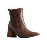 Bota tipo Chelsea de cuero marrón con paneles laterales elásticos, punta fina y taco cuadrado con efecto madera.