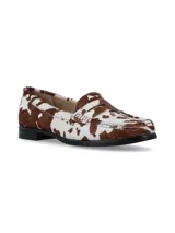 Mocasines de cuero con pelo, con estampado de manchas tipo vaca en tonos marrón y blanco. Presentan un diseño clásico de mocasín con antifaz y suela plana de goma negra.
