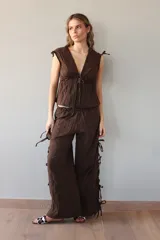 Pantalón negro de tejido ligero, corte holgado, cintura elastizada y aberturas laterales con lazos.