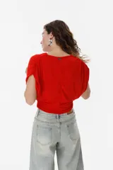 Top verde con escote drapeado y mangas cortas.