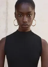 Vestido largo negro de punto fino, con cuello perkins y diseño sin mangas. Presenta un diseño entallado en la parte superior y falda evasé combinada de lyocell.