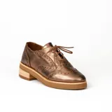 Zapato acordonado estilo oxford de cuero vacuno en color plateado metalizado, con diseño brogue, suela de goma y taco de madera.