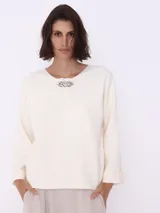 Sweater color crema de tejido de punto, con cuello redondo y prendedor de strass.