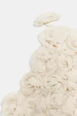 Top corto de cuello halter, confeccionado con una estructura de tejido que forma flores en relieve por toda la prenda. Presenta cierre en la espalda con abertura y botón oculto.