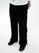 Pantalón de jean negro de corte regular fit y tiro bajo, con costuras decorativas verticales en el frente y diseño de pierna recta.