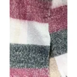 Bufanda rectangular de tejido grueso con diseño de cuadros en tonos azul, naranja, gris y beige, terminada con flecos en los extremos.