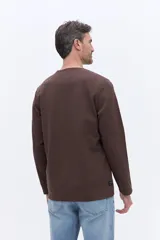 Remera de manga larga Brooksfield color marrón, con cuello redondo y textura sutil. Presenta un estampado frontal con el logo y leyenda de la marca.