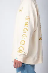 Buzo negro de corte oversize con cuello redondo y mangas largas. Presenta un pequeño logo estampado en el pecho y un diseño de empanadas y textos en la manga.