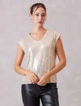 Blusa sin mangas con escote en V, confeccionada completamente en lentejuelas color dorado. Cuenta con forro interno a tono y un corte recto y holgado.
