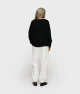 Pantalón deportivo de corte holgado, color blanco, con cintura elástica ajustable con cordón, bolsillos laterales y puños elásticos en los tobillos.