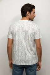 Remera de manga corta con cuello redondo, confeccionada en algodón con estampado botánico de hojas en tonos verdes.