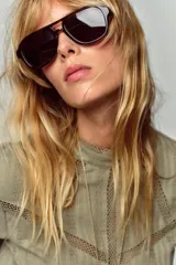 Camisa verde claro con cuello alto de puntilla, manga larga y detalles de entredoses calados en el pecho y los hombros. Cierre en la espalda con abertura y botón oculto.