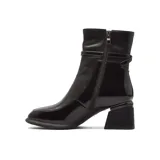 Bota de vestir de caña media confeccionada en cuero negro con acabado brillante. Presenta un diseño de punta cuadrada, taco geométrico ancho y una tira decorativa con hebilla metálica en la parte superior del tobillo.