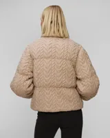 Campera puffer beige con cuello alto acanalado, cierre frontal con cremallera y bolsillos laterales.