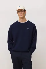 Sweater de punto de cuello redondo en color azul marino, con diseño de calce holgado y pequeño logo bordado en el pecho.