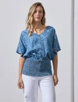 Blusa celeste con estampado floral, escote en V y ruedo smock.