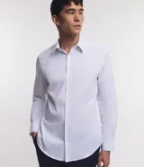 Camisa de vestir blanca de algodón con textura maquinetada, cuello camisero y mangas largas.