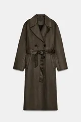 Abrigo largo color marrón oscuro con efecto ante, cuello solapa, manga larga con trabillas en los hombros y bolsillos delanteros de vivo. Presenta un bajo con abertura en la espalda y cierre frontal cruzado con botones, complementado con un cinturón a tono.