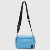 Cartera tipo bandolera de diseño acolchado, color celeste, con múltiples compartimentos con cierre y correa ajustable de cinta negra con logo grabado.