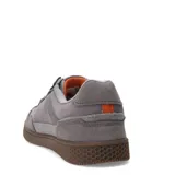 Championes urbanos Caterpillar modelo Pause Retro Leather, color gris con detalles en cuero y gamuza. Presentan suela de goma color marrón con textura hexagonal y cierre mediante cordones.