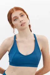 Top deportivo azul con textura acanalada y tirantes anchos.