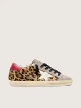 Zapatilla de cuero vacuno con pelo de potro y estampado animal print, combinada con gamuza en la puntera y lengüeta. Presenta una estrella lateral de cuero blanco, detalle de cuero rojo en el talón, cordones oscuros y suela con efecto envejecido.