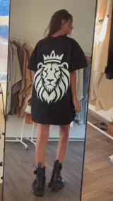 Remera oversize de color negro con estampado grande de un león con corona en la espalda en color blanco.
