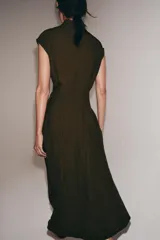 Vestido midi de Zara Woman Collection, confeccionado en mezcla de viscosa y lyocell. Presenta cuello perkins con lazada frontal, diseño sin mangas, pliegues en la cintura y cierre posterior con abertura y botones.