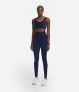 Calza legging deportiva de tiro alto, color azul marino, confeccionada en tejido de poliamida y elastano. Presenta un diseño liso, ajustado al cuerpo y largo hasta el tobillo, ideal para actividades físicas.
