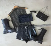 Short negro de cuero sintético con cintura alta, corte holgado, cinturón con hebilla metálica y bolsillos laterales.