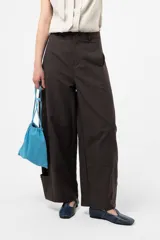 Pantalón gris oscuro de pierna amplia y tiro alto, con calce relajado, recortes y bolsillos cargo en la parte inferior.